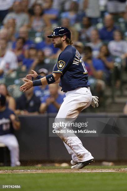 Kirk Nieuwenhuis of the Milwaukee Brewers celebrates after an RBI single hit by Ryan Braun during the first inning against the Chicago Cubs at Miller...