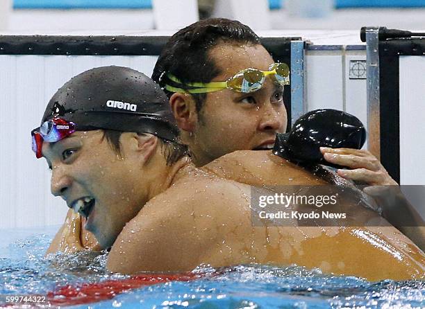 Britain - Japan's Ryo Tateishi embraces compatriot Kosuke Kitajima after finishing third in the men's 200-meter breaststroke final at the Aquatics...