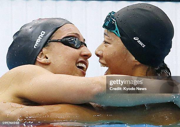 Britain - Satomi Suzuki of Japan celebrates with Rebecca Soni of the United States after the women's 200-meter breaststroke final at the Aquatics...