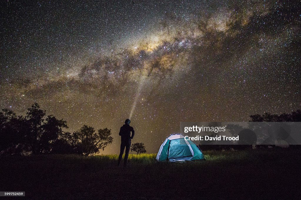 Man shining a light into the Milky Way.