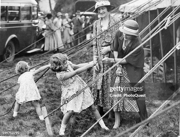 This charming snapshot, taken at the Abergeldie Castle Fete, behind the marquee in which the two little Princesses sold white heather in aid of the...