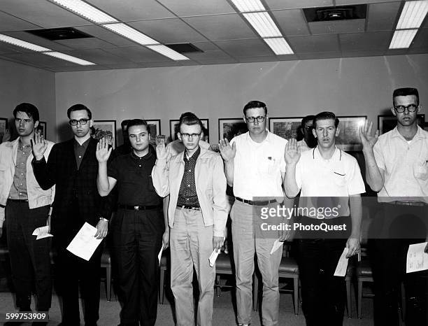 Inductees taking the oath as they are sworn into the Army, March 6, 1965. They have just completed their physical exams and will leave for Fort...