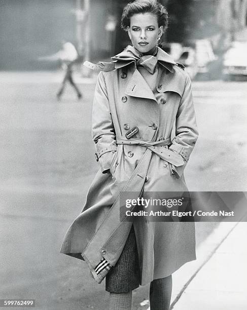Model, Lisa Taylor, walking with her hands in pockets, and wearing a Burberry khaki cotton poplin trenchcoat with the signature plaid lining CREDIT...