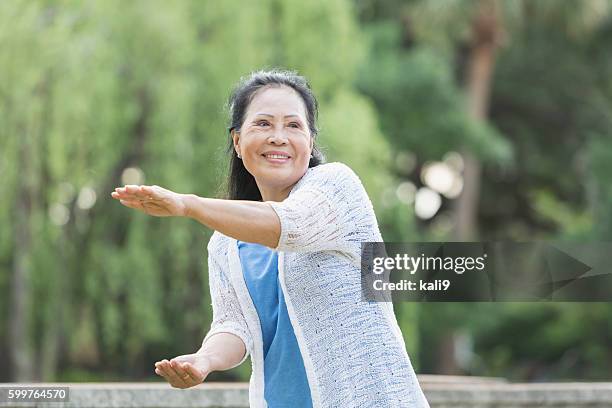 senior asian woman doing tai chi - woman and tai chi stock pictures, royalty-free photos & images