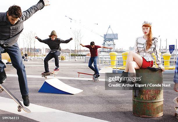 Skateboarders riding around a young woman modeling a Pollini belted jacket, 3.1 Phillip Lim shorts, Luella hair bow, Wayne bag, Madison Harding...