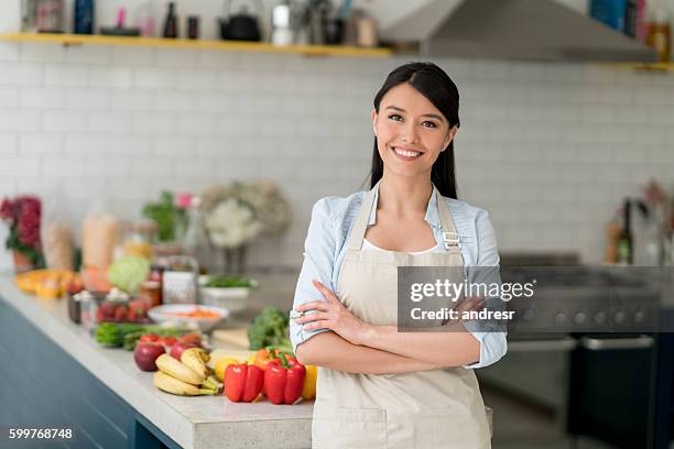 happy woman cooking at home - apron stockfoto's en -beelden