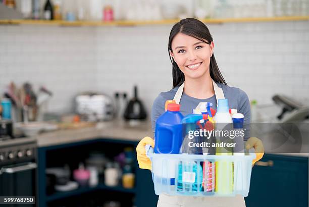 housekeeper holding cleaning products - housework stock pictures, royalty-free photos & images