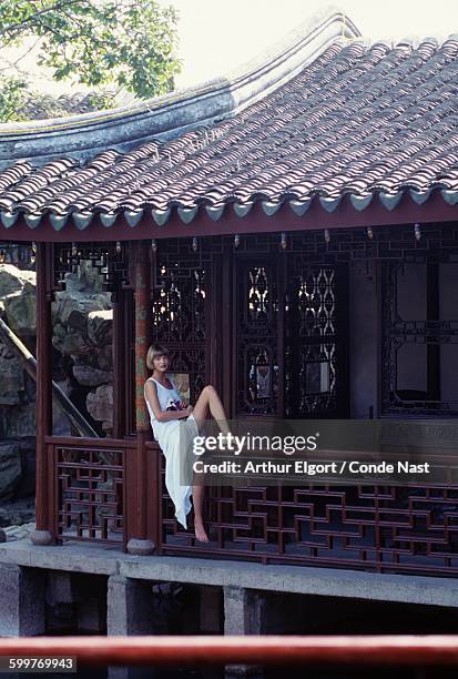 Model, Linda Evangelista, sitting on railing at the Chinese pavilion, Suzhou's Wang shi Garden, wearing gauze dress by Franco Moschino CREDIT MUST...