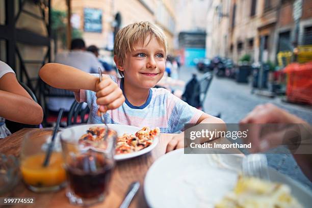 little boy enjoying lunch in rome street restaurant - kid eating restaurant stock pictures, royalty-free photos & images