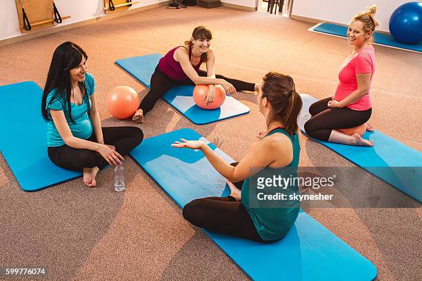 smiling pregnant women relaxing after pilates training and talking. - aerobic stockfoto's en -beelden