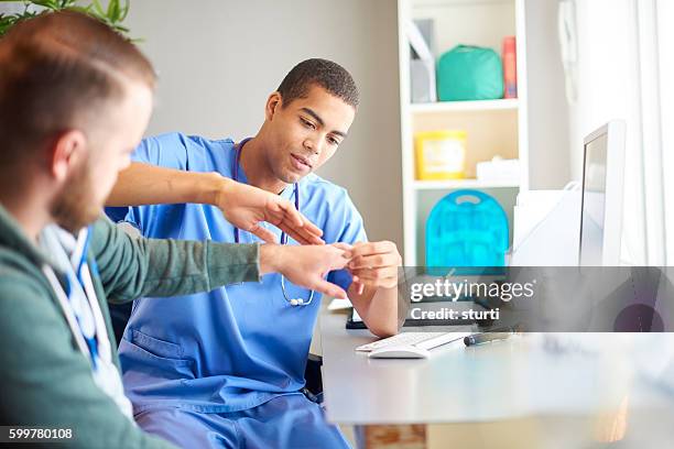 examining patients hand - african injured stock pictures, royalty-free photos & images