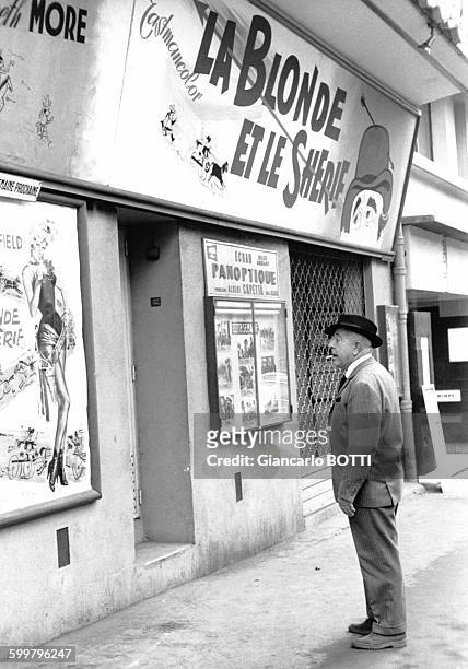 Le poète Jacques Prévert devant un cinéma, circa 1960, à Paris, France .