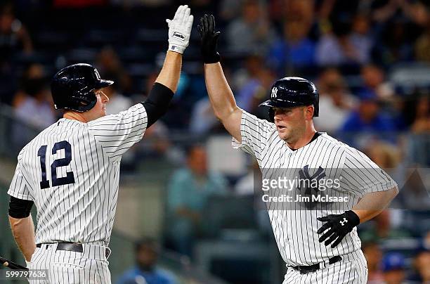 Brian McCann of the New York Yankees celebrates his fourth inning home run against the Toronto Blue Jays with teammate Chase Headley at Yankee...