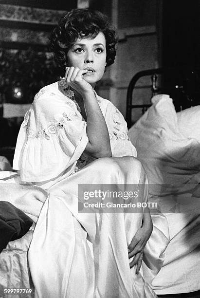 Actrice Jeanne Moreau en chemise de nuit assise sur un lit durant une scène du film de Bunuel, en novembre 1963, en France .