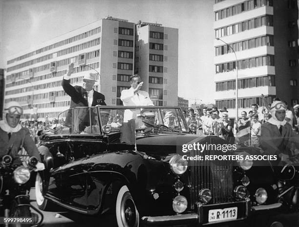 Les dirigeants de l'URSS et de la Yougoslavie Nikita Khrouchtchev et Josip Broz Tito saluant la foule de leur voiture .