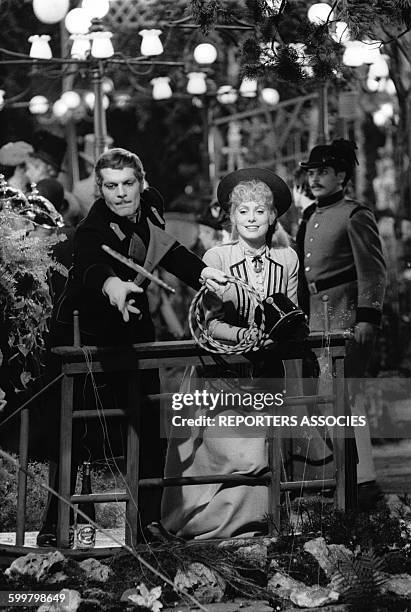 Acteur égyptien Omar Sharif et la comédienne Catherine Deneuve lancent des anneaux sur une attraction de fête foraine pour le film de Terence Young...