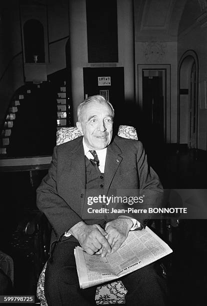 Le prix Nobel de physique 1970 Louis Néel assis dans un fauteuil de l'hôtel Paris-Lyon palace, un journal sur les genoux, le jour où lui a été...