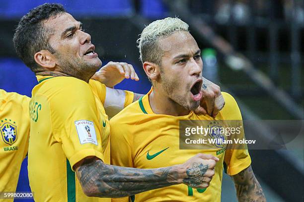 Neymar Jr of Brazil celebrates with teammate Dani Alves after scoring the second goal of his team during a match between Brazil and Colombia as part...