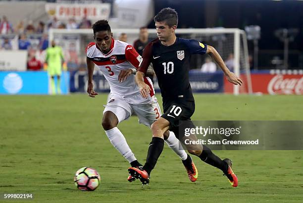 Christian Pulisic of the United States drives past Joevin Jones of Trinidad & Tobago during the FIFA 2018 World Cup Qualifier at EverBank Field on...