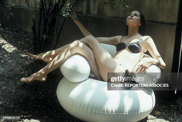 Jeune femme posant en maillot de bain sur un fauteil gonflable .