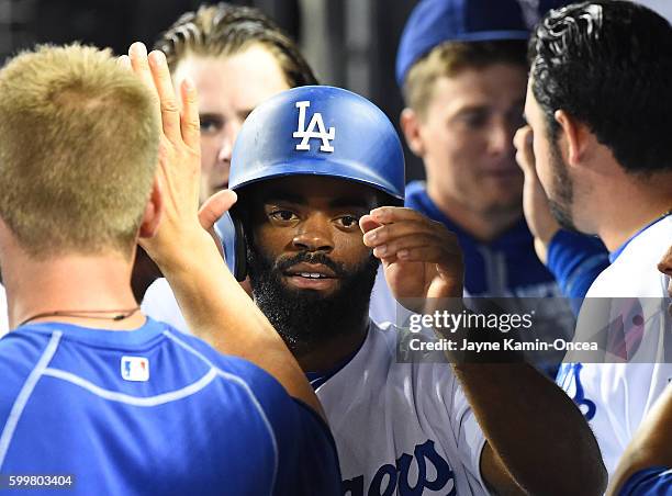 Andrew Toles of the Los Angeles Dodgers is greeted in the dugout after scoring a run in the second inning of the game against the Arizona...