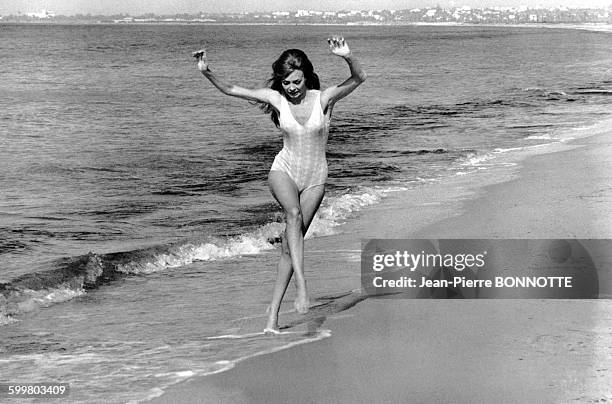 Actrice Michèle Mercier joue avec les vagues .