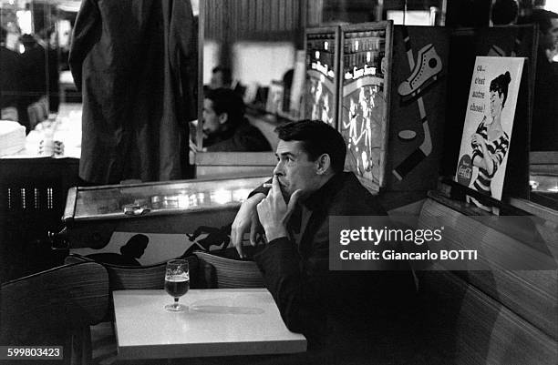 Le chanteur Jacques Brel dans un café parisien en 1965, à Paris, France .