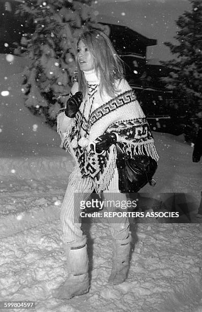 Actrice Brigitte Bardot en poncho sous la neige, circa 1960 en France .