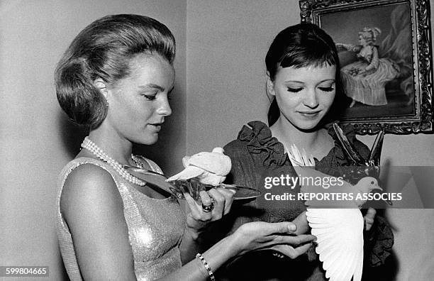Les actrices Romy Schneider et Anna Karina tenant deux colombes blanches sur leurs mains, circa 1960 en France .