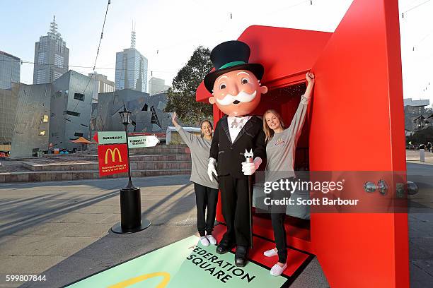 McDonalds super-fans Laura Paton and Emma Kendrick pose with Mr. Monopoly as they relax in McDonalds Monopoly Hotel at Federation Square on September...