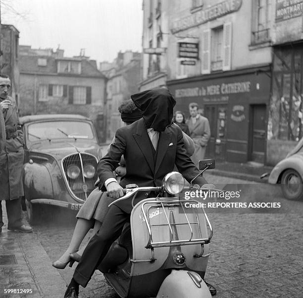 Stupid bet as driving a Moped with a bag on the head, in France, circa 1950 .