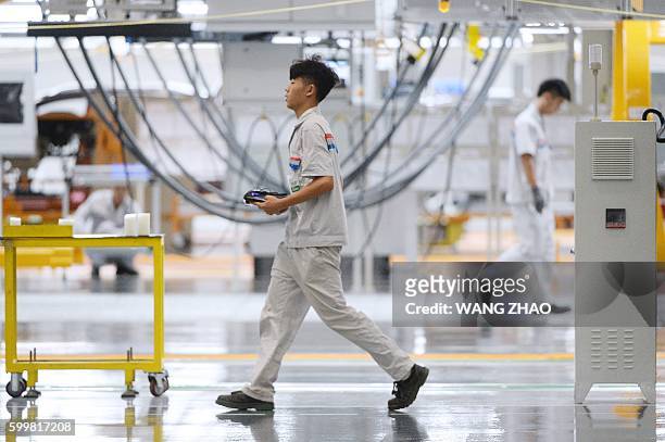Chinese staff work on the assembly line at the start of production on the DPCA Chengdu plant and Dongfeng Peugeot 4008 line in Chengdu on September...