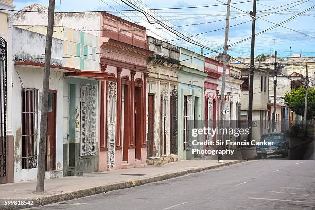 colonial style street with lone vintage cuban car in cienfuegos, cuba - cienfuegos stockfoto's en -beelden