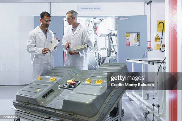 scientists inspecting lithium ion car battery components in battery research facility - autobatterie stock-fotos und bilder