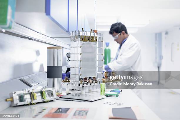 scientist assembles lithium ion battery samples in battery research facility - onderzoeksfaciliteit stockfoto's en -beelden