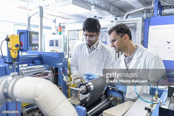 scientists with lithium ion battery production line in battery research facility - lithium ion battery stock pictures, royalty-free photos & images