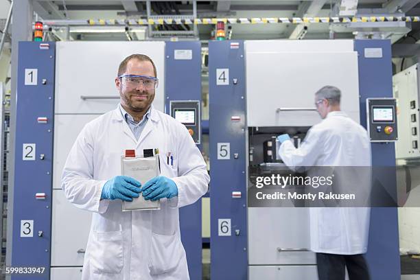 scientist with lithium ion pouch cell manufacture machine in battery research facility, portrait - lithium ion battery stock pictures, royalty-free photos & images