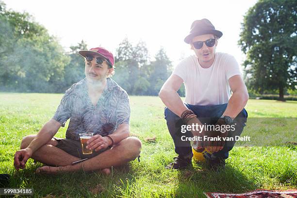 portrait of two cool male friends at park party - alcohol and smoking stock pictures, royalty-free photos & images