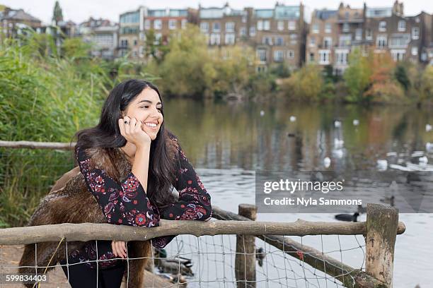 young woman relaxing by lake, hampstead heath, london - ハムステッド ストックフォトと画像