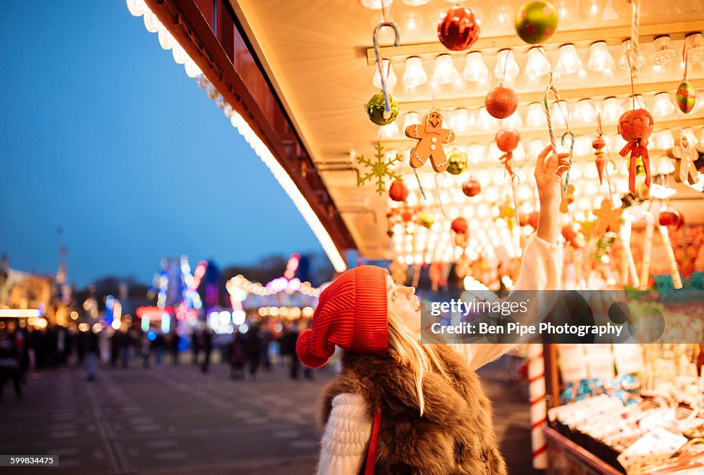 Young woman choosing baubles at xmas festival in Hyde Park, London, UK