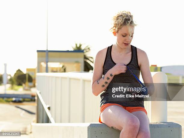 young female boxer wrapping hands in bandage at parking lot - bandage stock pictures, royalty-free photos & images