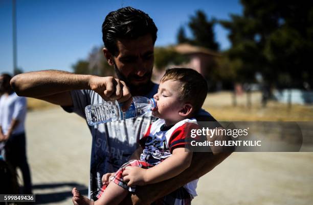 Syrian refugees walk on their way back to the Syrian city of Jarabulus on September 7, 2016 at Karkamis crossing gate, in the southern region of...