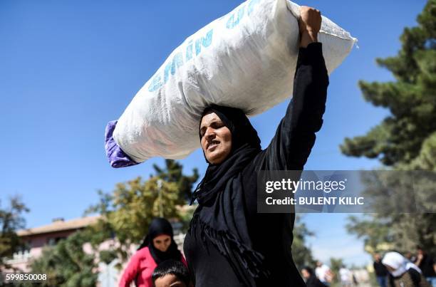 Syrian refugees walk on their way back to the Syrian city of Jarabulus on September 7, 2016 at Karkamis crossing gate, in the southern region of...