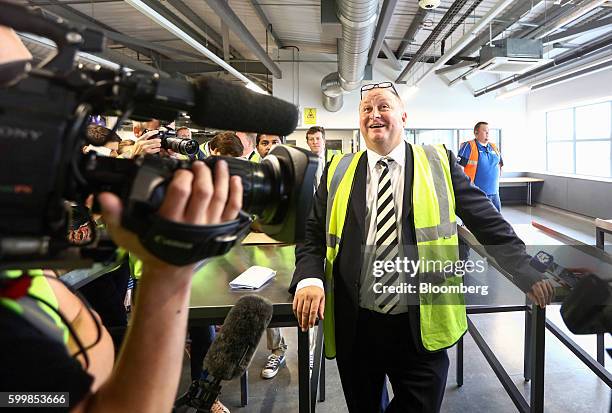 Mike Ashley, billionaire and founder of Sports Direct International Plc, talks to members of the media during a tour of the company's warehouse...