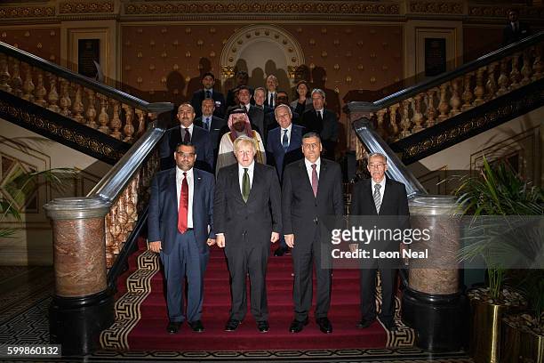 Britain's Foreign Secretary Boris Johnson and Chief Negotiator for the Syrian Opposition Dr Riyad Hijab stand with members of the Syrian High...