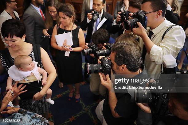 Emily Holubowich and her 6-month-old daughter Jackie are the focus of photographers following a news conference about funding programs to combat the...