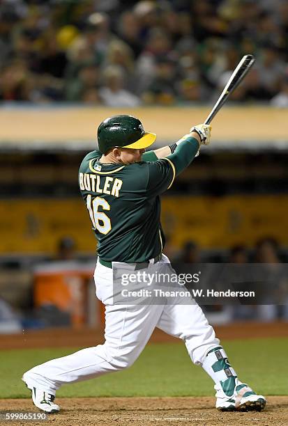 Billy Butler of the Oakland Athletics hits a sacrifice fly scoring Jake Smolinski against the Boston Red Sox in the bottom of the fourth inning at...