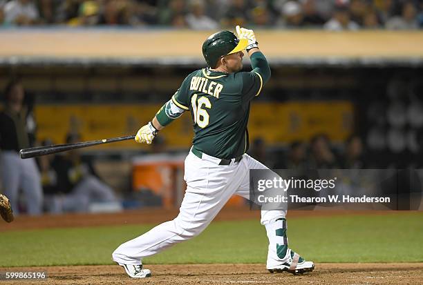 Billy Butler of the Oakland Athletics hits a sacrifice fly scoring Jake Smolinski against the Boston Red Sox in the bottom of the fourth inning at...