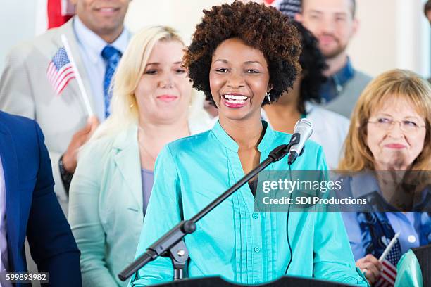 mujer sonriendo mientras habla en un mitin o evento político local - politician fotografías e imágenes de stock