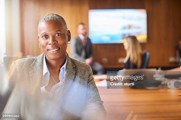 smiling senior businesswoman and her team - androgynous stock pictures, royalty-free photos & images